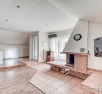 Nappali kandallóval egy családi házban, fa dekoros padlóval, tágas ablakokkal.