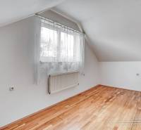 Szoba egy családi házban, ablakkal és fa dekorációjú padlóval.