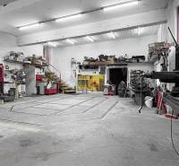 Műhely szerszámokkal és lépcsőkkel egy családi házban. Mennyezetek világítással és betonpadló.