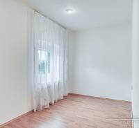 Világos szoba fa mintás padlóval és függönyökkel egy családi házban.