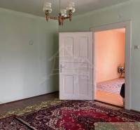 Szoba családi házban szőnyeggel, fehér ajtókkal és csillárral.