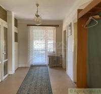 Családi ház belső tere fa dekorációjú padlóval, függönnyel és szőnyeggel.