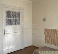 Családi ház belső tere fehér ajtókkal, fa dekorációjú burkolattal és padlóval.