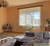 Nappali egy családi házban kanapéval, szőnyegekkel és hi-fi berendezéssel.