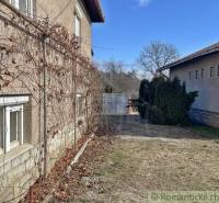 Családi ház Bretkán régi homlokzattal, szőlővel és fákkal teli udvarral.