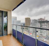 Kilátás egy háromszobás lakás erkélyéről a Pozsonyi Plynárenská utcában. Üvegkorlát.