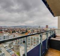 Kilátás egy háromszobás lakás erkélyéről a Pozsonyi Plynárenská utcában kerti bútorokkal.