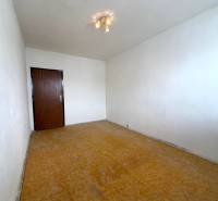 Szoba fehér falakkal és fa dekorációjú padlóval egy kétszobás lakásban.