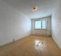 Üres szoba egy kétszobás lakásban fehér falakkal és fa mintás padlóval.