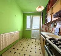 Zöld konyha egy kétszobás lakásban csempékkel és gáz tűzhellyel.