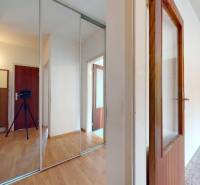 Folyosó egy kétszobás lakásban, fa mintázatú padlóval és tükrös szekrénnyel.