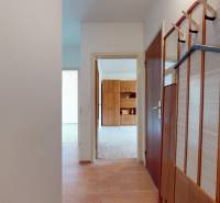 Előszoba egy kétszobás lakásban, fali fogassal és fa dekorációjú padlóval.