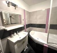 Fürdőszoba káddal, mosdóval és tükörrel egy kétszobás lakásban.