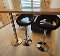 Stúdiólakás pulttal, székekkel és fa dekorációjú padlóval.