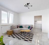 Nappali sarokkanapéval, étkezőasztallal és erkéllyel egy háromszobás lakásban.