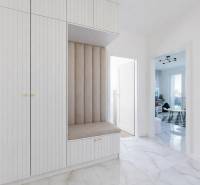 Előszoba egy 3 szobás lakásban, harmonizáló bútorokkal és márványmintás padlóburkolattal.