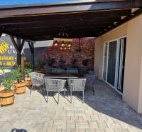 Újfalusi vendéglátóhelyek kültéri ülőhellyel és téglafallal.