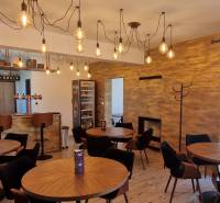 Gasztró terek függő lámpákkal, fa dekorációval és hangulatos ülőhelyekkel.