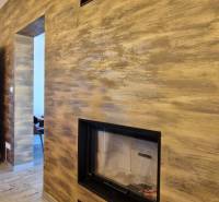 Beltéri vendéglátó helyiség kandallóval és fa dekorációjú padlóval.