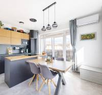 Konyha egy háromszobás lakásban fa dekoros padlóval, étkezőasztallal és modern légkondicionálóval.