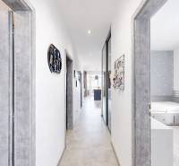 Folyosó egy 3 szobás lakásban fehér falakkal, szürke ajtókkal és világos padlóval.