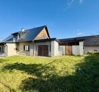 Családi ház Sárosfeketén gyepesített udvarral, modern tetővel és részben fából készült falakkal.