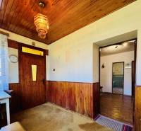 Fa burkolat a falakon és a mennyezeten, színes csillár, asztal egy családi házban.