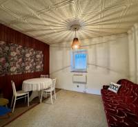 Családi ház belső tere fa burkolattal és virágmintás képpel a falon.