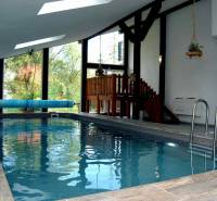 Egy nyaraló apartman belső tere fa dekorációjú padlóval és fedett medencével.