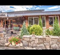 Kő homlokzatú rekreációs apartman Csorbán terasszal és virágdíszítéssel.