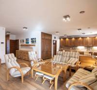 Családi ház belső tere tágas nappalival, konyhabútorral és fa mintázatú padlóval.