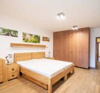 Hálószoba családi házban ággyal, szekrényekkel és fa dekorációjú padlóval.