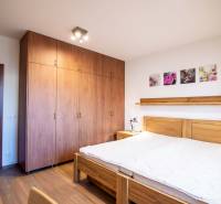 Hálószoba fa bútorokkal és fa dekorációjú padlóval egy családi házban.