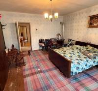 Szoba egy családi házban hagyományos ággyal, ruhásszekrénnyel és kerékpárral.