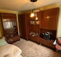 Szoba egy családi házban bútorokkal, ággyal és mintás tapétával a falakon.