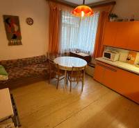 Családi ház belső tere retro konyhával, kerek asztallal és kanapéval.