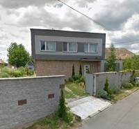 Családi ház Bystričkán gondozott kerttel és magas kerítéssel az utca mentén.