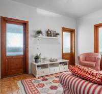 Nappali egy négy szobás lakásban piros csíkos fotelekkel és falra szerelt polccal.