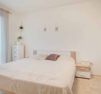 Világos hálószoba beépített szekrénnyel és dekorációs elemekkel egy háromszobás lakásban.