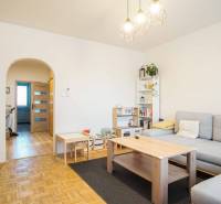 Nappali egy háromszobás lakásban, fa dekoros padlóval és világos bútorokkal.