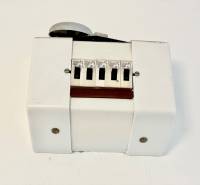 Egy szobás lakás fehér műanyag burkolattal és kapcsolókkal.