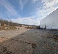 Gyártóhelyiségek Nagykürtösön aszfaltozott területtel és kerítéssel, ipari övezet.