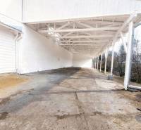 A nagykeresztúri gyártóhelyiségek külső része betonpadlóval és fehér falakkal.