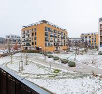 Hóval borított járdákkal és zöldterülettel körülvett épület a Pozsony-Petržalka Béžová utcában.