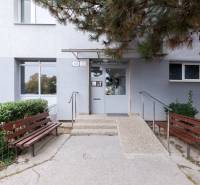 A pozsonyi Vyšehrad utca épületének bejárata - Pozsonyligetfaluban, padokkal és zöldterülettel.