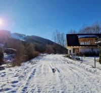 Havas út a ház előtt az utcán Mýto pod Ďumbieromban, napsütéses téli napon.