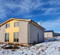 Ház Dolná Lehota-ban fa burkolattal, havas táj és hegyek a láthatáron.