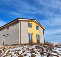 Ház Dolná Lehota-ban fa dekorációval, havas telek és felhős égbolt.