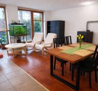 Nappali egy háromszobás lakásban, fa dekoros padlóval, étkezőasztallal és akváriummal.