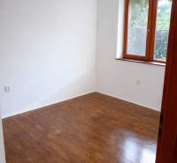 Szoba fa dekorációval, fehér falakkal, ablakkal, bútor nélkül egy háromszobás lakásban.